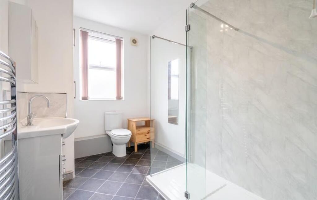 This stylish bathroom features a spacious showe...