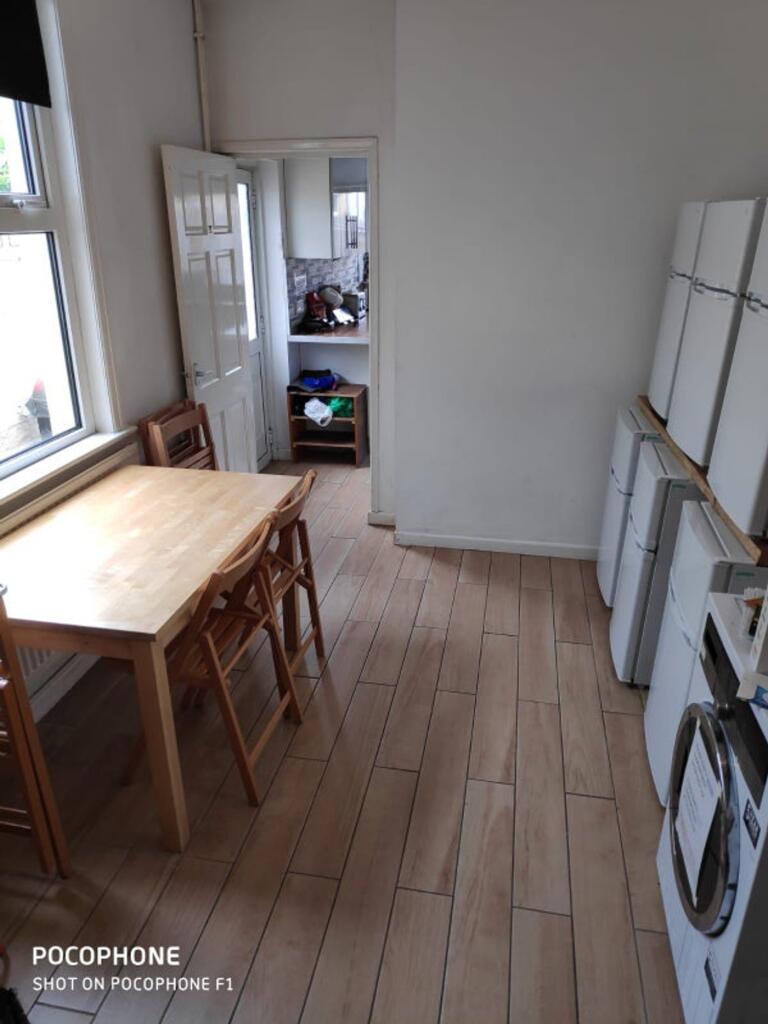 A clean kitchen with a table and several white ...