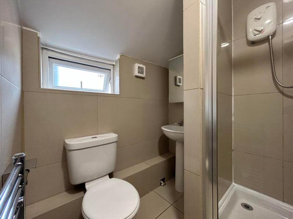 A modern and tidy bathroom featuring a shower a...