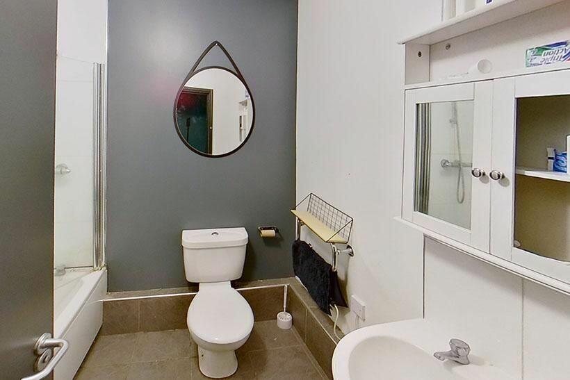 A clean and modern bathroom featuring a bathtub...