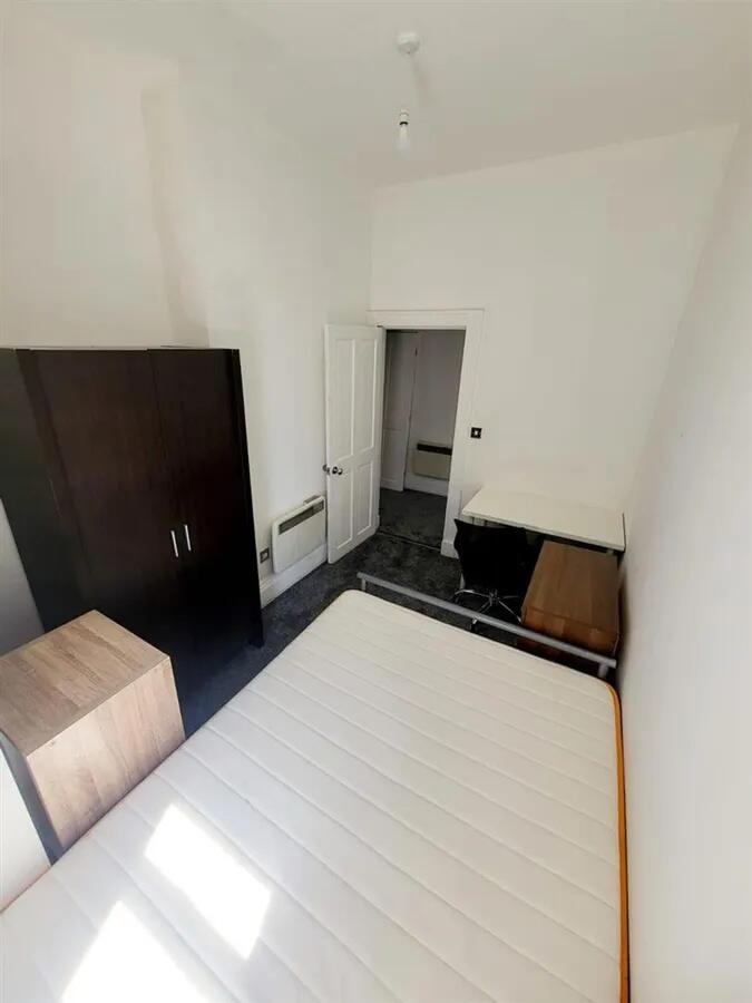 Bright double bedroom featuring a large bed wit...