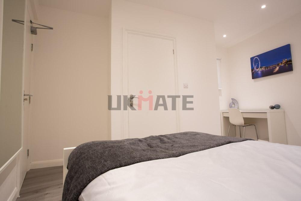 A modern and tidy bedroom featuring a comfortab...