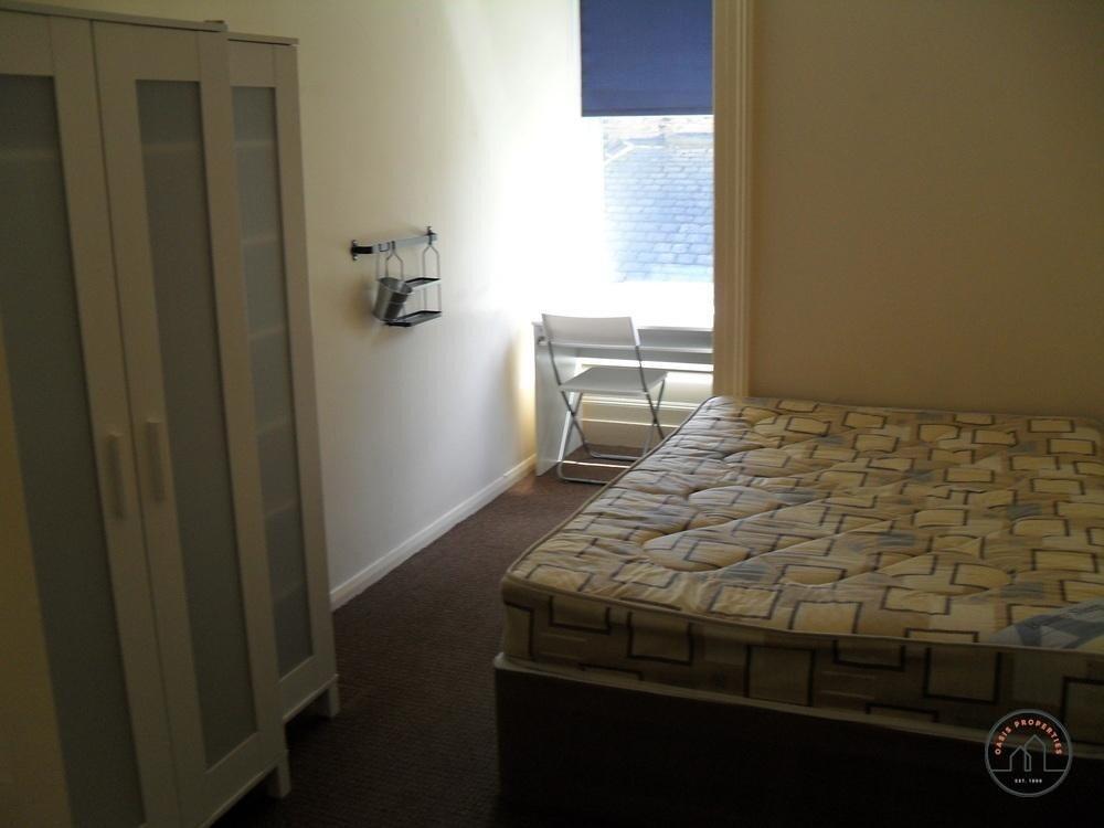 A tidy bedroom featuring a comfortable double b...