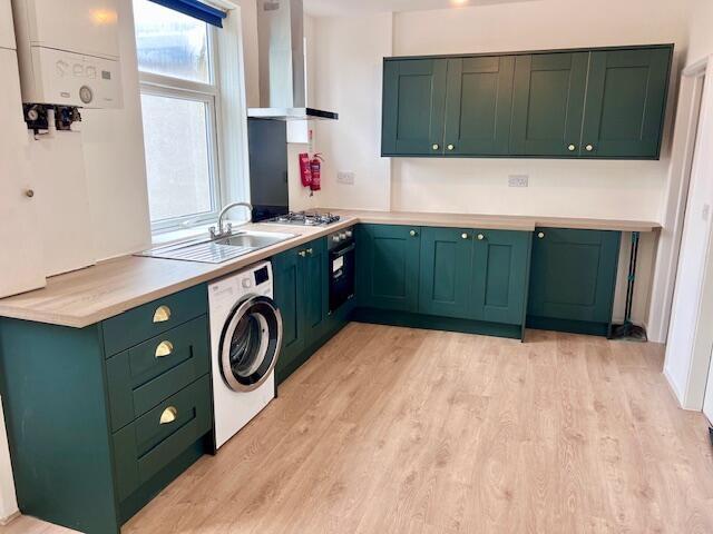 Bright and modern kitchen featuring stylish gre...