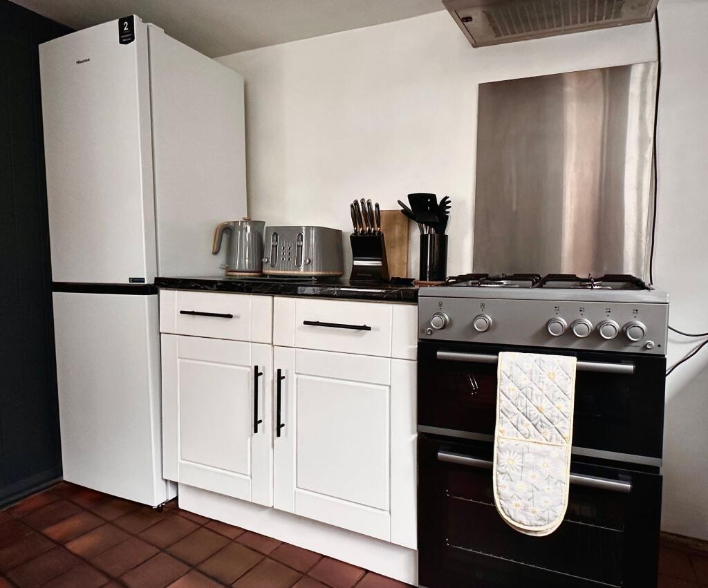 A modern kitchen featuring a clean white fridge...