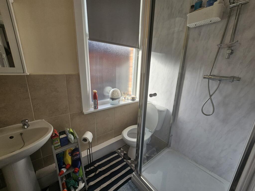 A clean, modern bathroom featuring a walk-in sh...