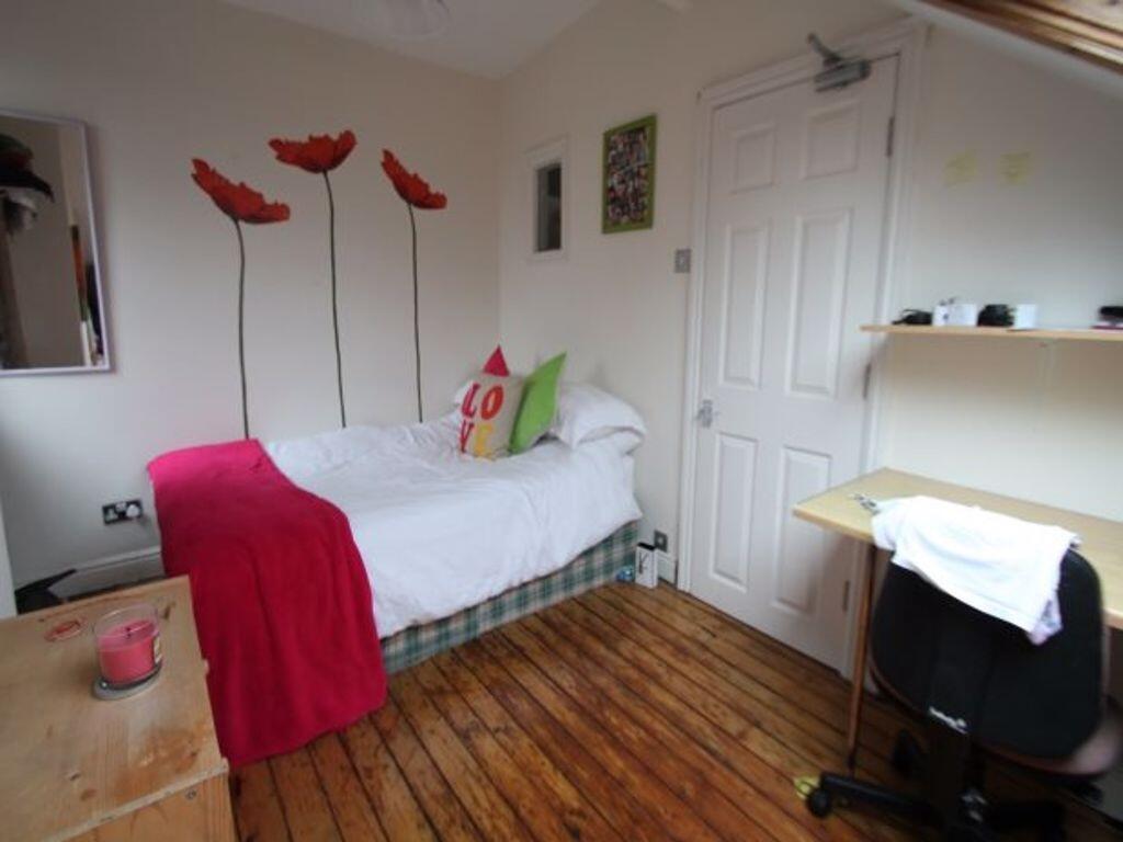 A cozy single bedroom featuring a comfortable b...