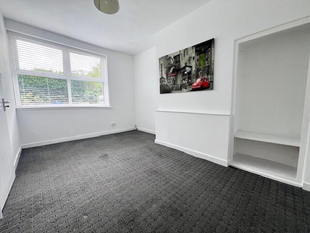 Bright single bedroom featuring a large window ...