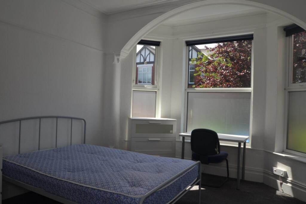 This inviting double bedroom features large win...