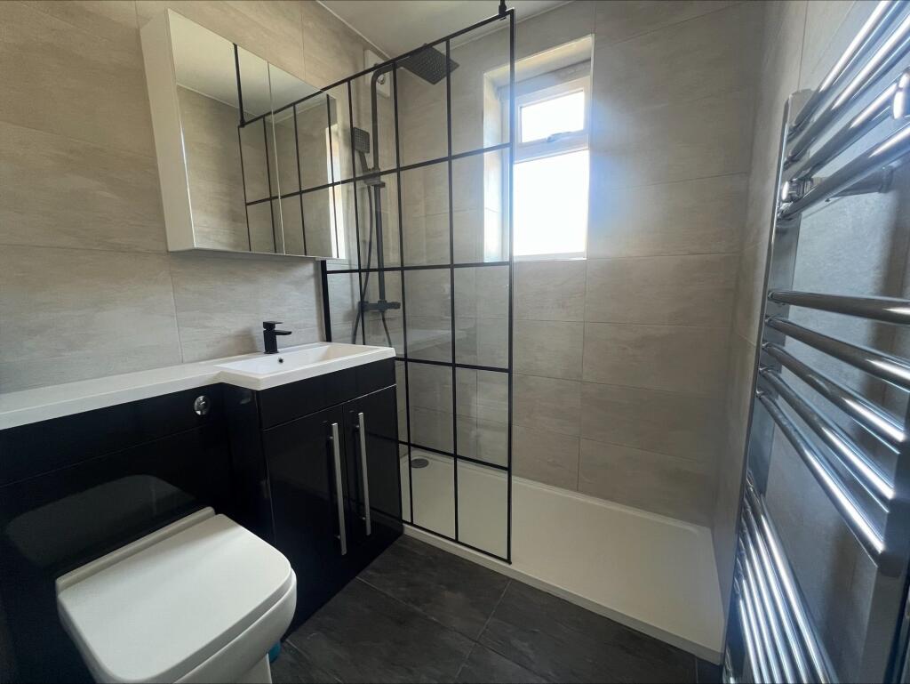 Modern bathroom featuring sleek black cabinetry...