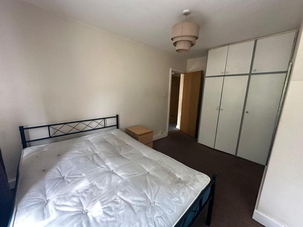 A bright double bedroom featuring a large bed, ...