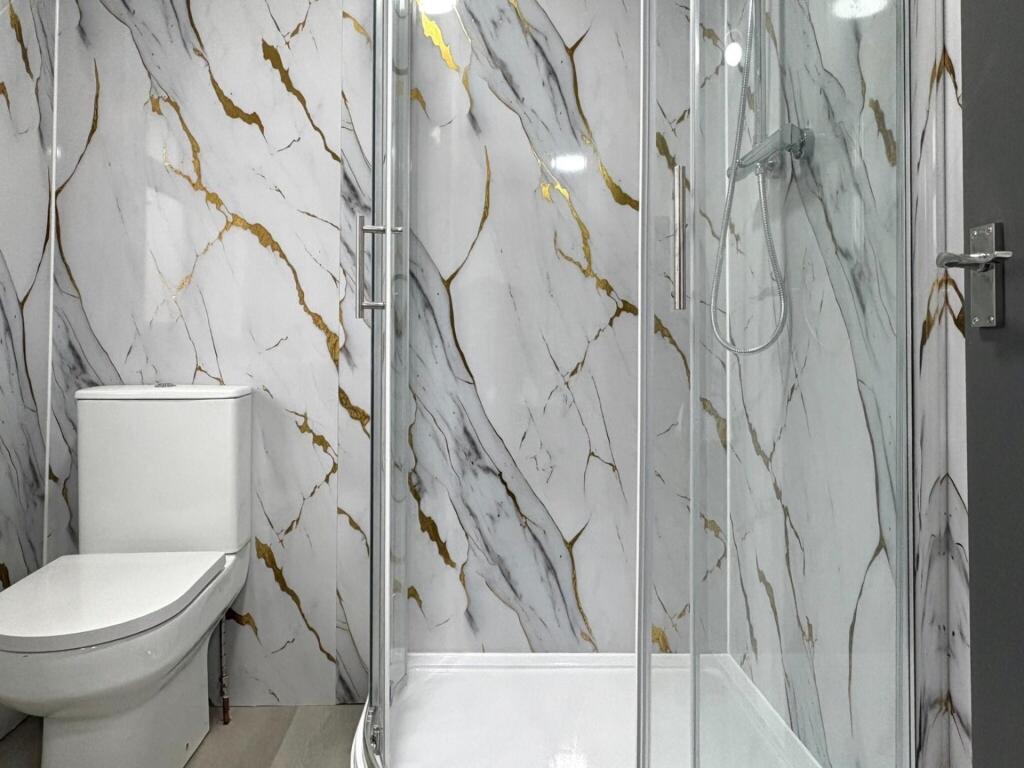 Modern bathroom with a glass-enclosed shower an...