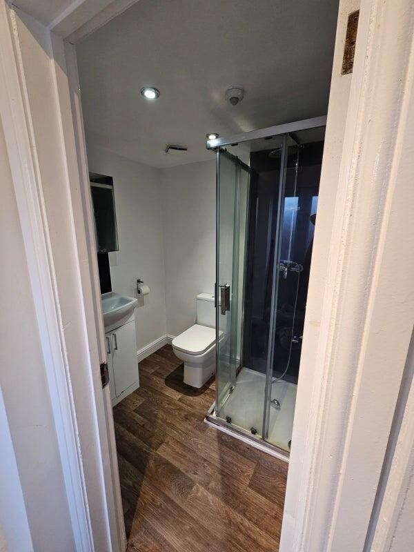 Modern bathroom featuring a glass-enclosed show...