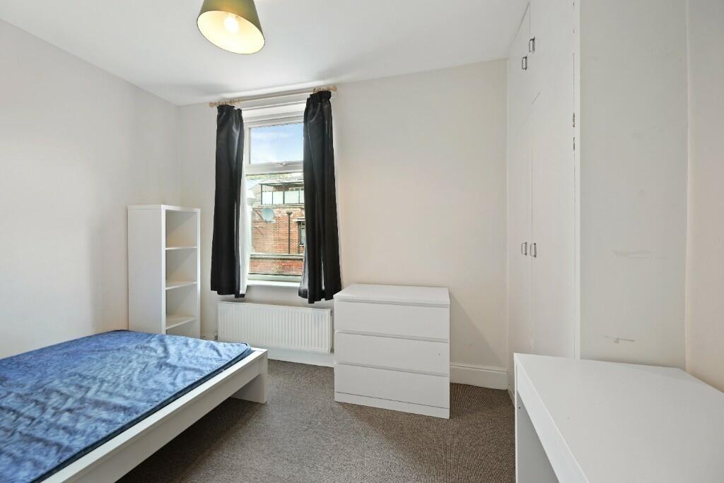 A tidy and bright single bedroom featuring a si...