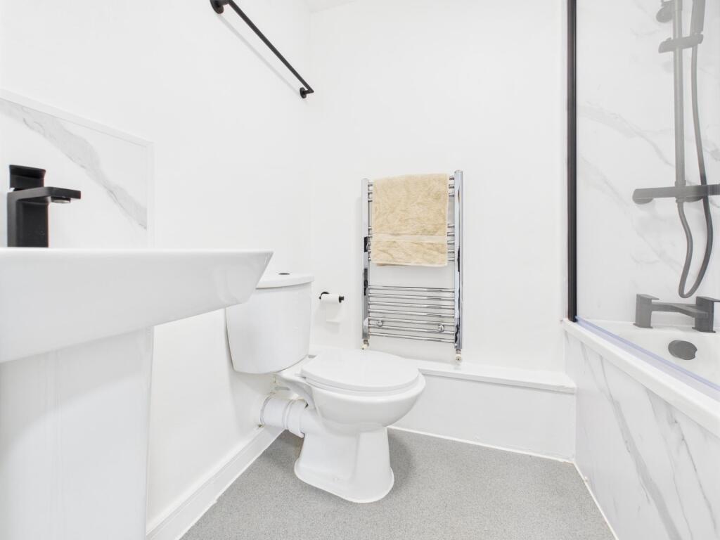 Bright and clean bathroom featuring a toilet, b...