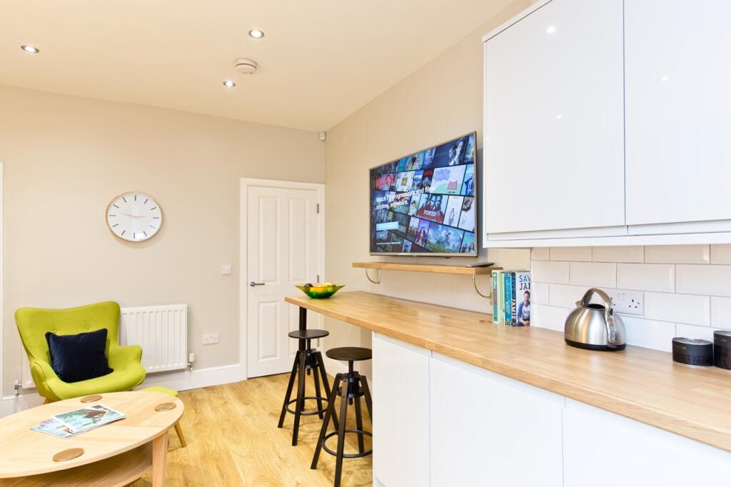 Modern kitchen with white cabinetry, a wooden c...