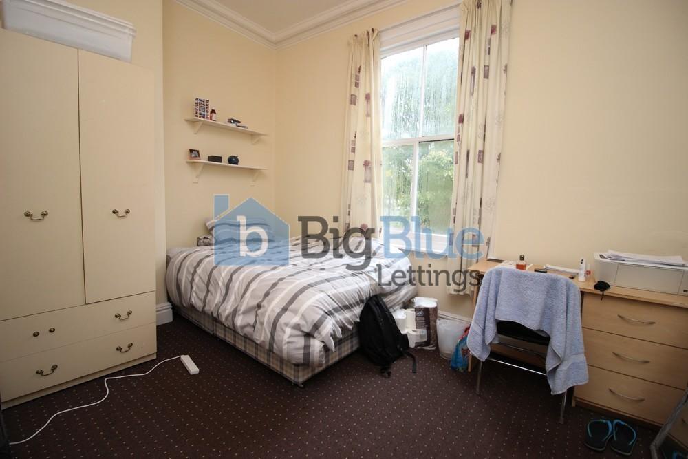 Cozy single bedroom featuring a comfortable bed...