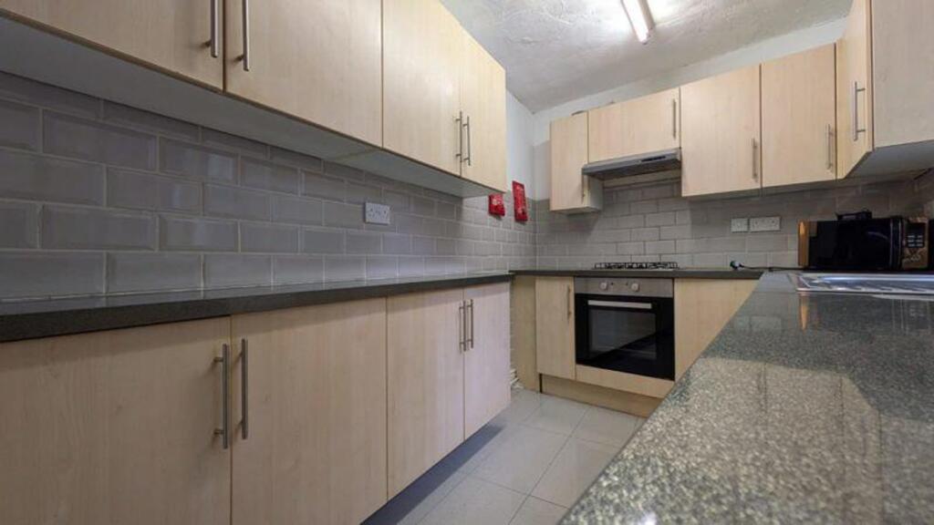 A modern and tidy kitchenette with ample storag...