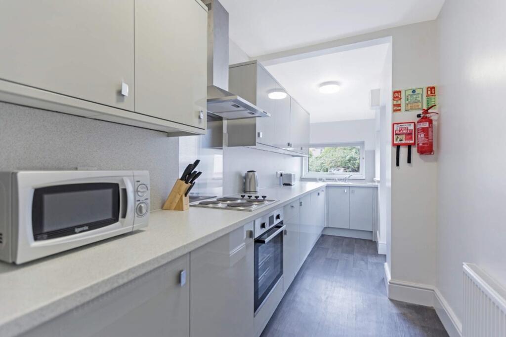 A modern and tidy kitchenette featuring ample s...