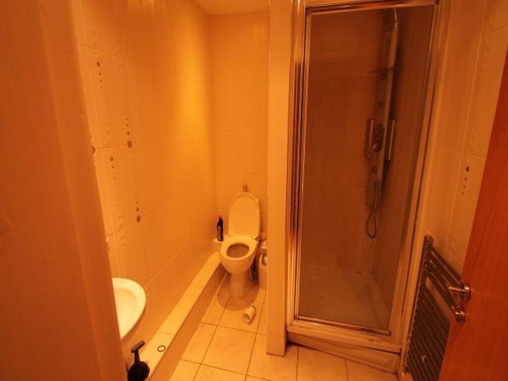 Compact and functional bathroom featuring a sho...