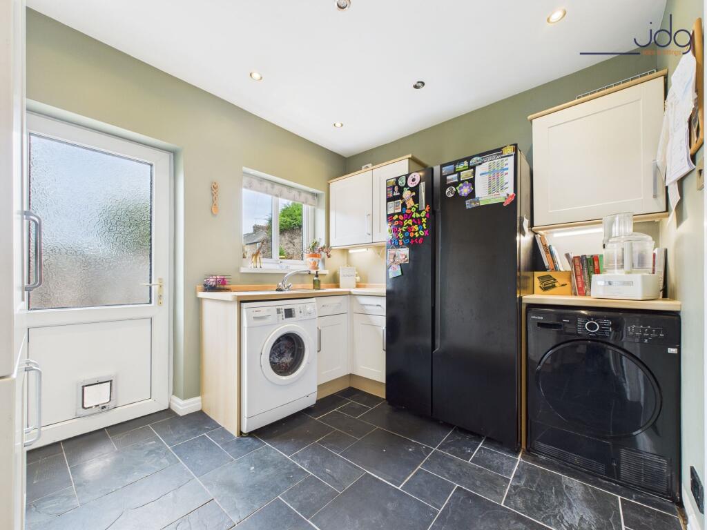 Kitchen flowing openly into a matching utility room
