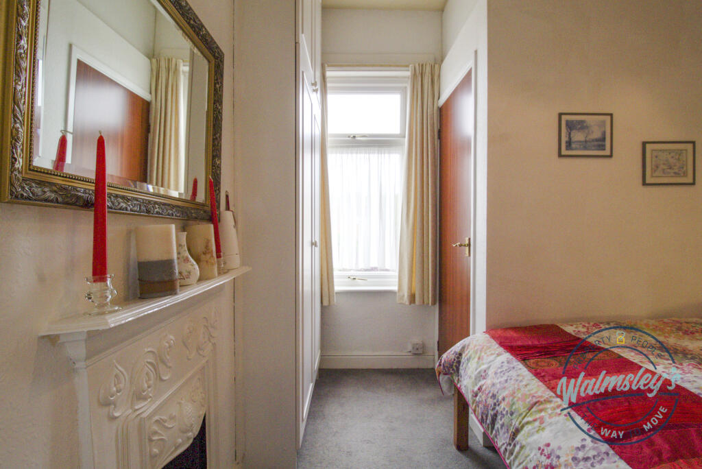 Bedroom to rear with original fireplace and cloakr