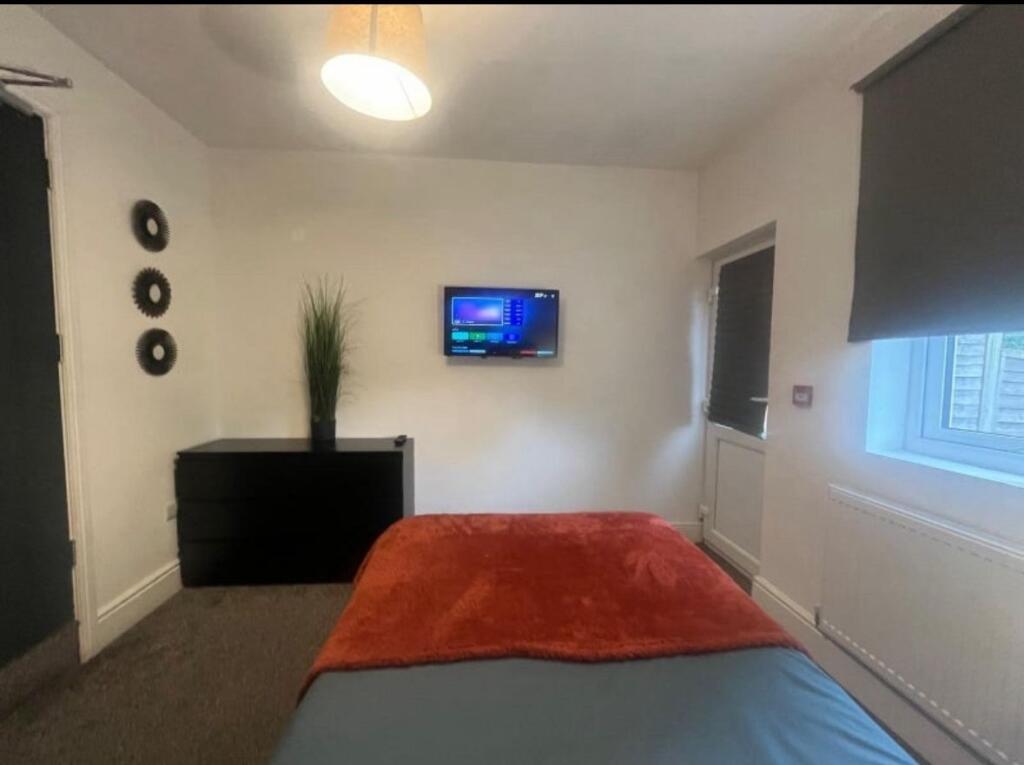 A cozy single bedroom featuring a comfortable b...