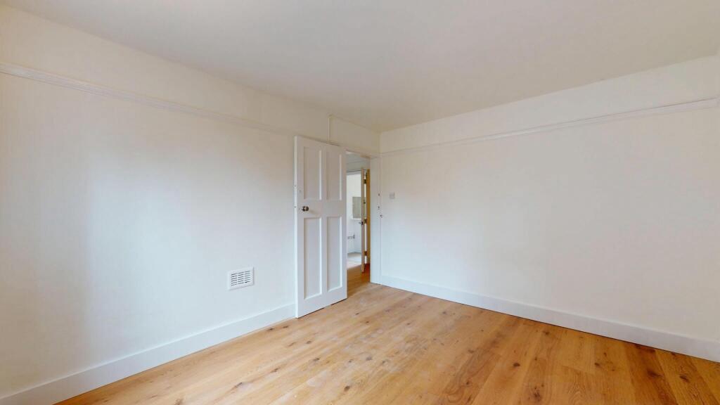 A bright, clean bedroom with neutral walls and ...