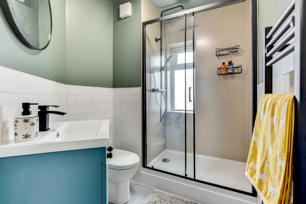 A stylish bathroom featuring a modern shower en...