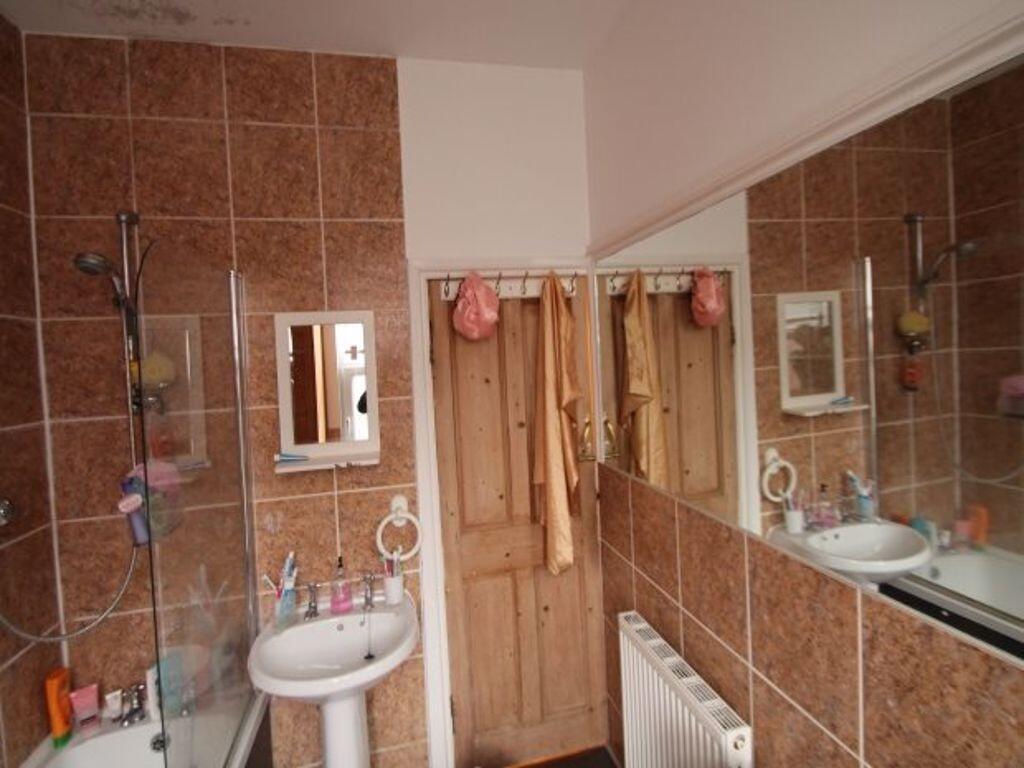 Bright and clean bathroom suite featuring a whi...