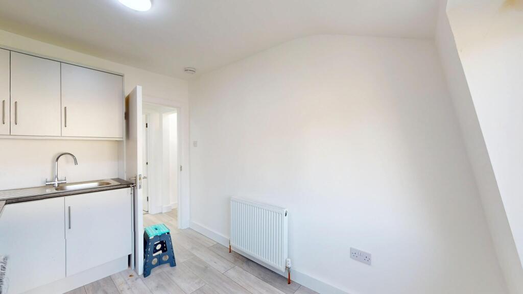 A bright, minimalist kitchen with white cabinet...