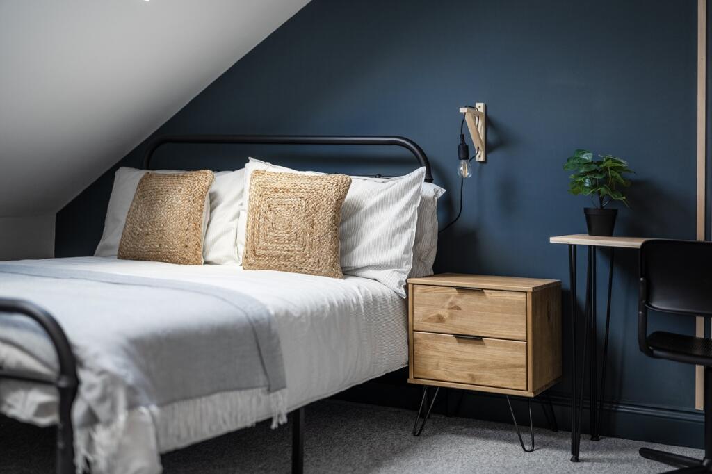 A tidy double bedroom featuring a bed with deco...