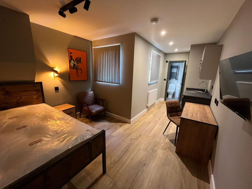 Well-presented double bedroom with a wooden bed...