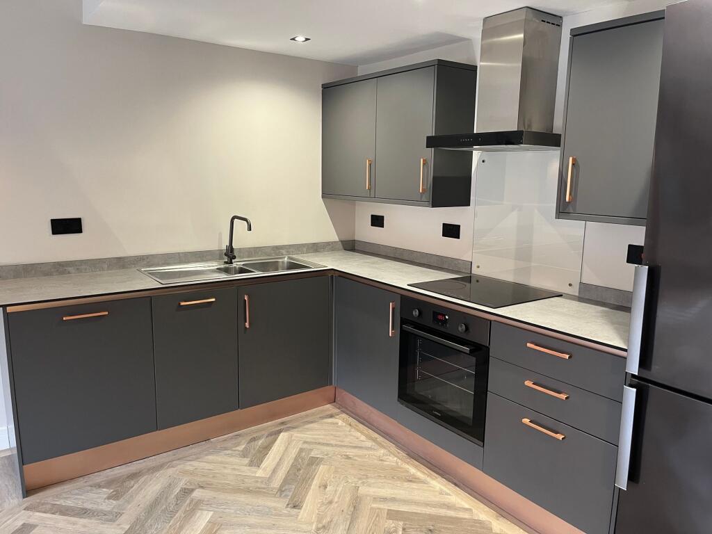 A modern kitchen featuring sleek grey cabinets ...
