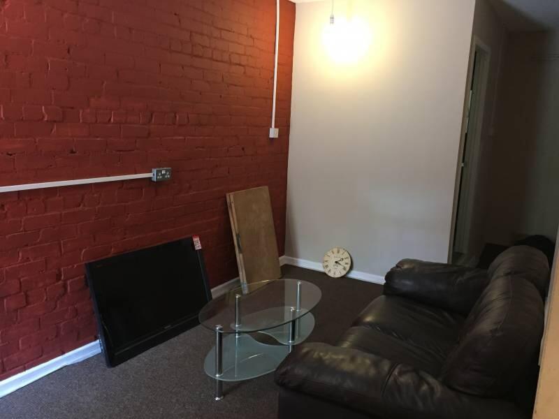 A cozy living room featuring a black leather so...
