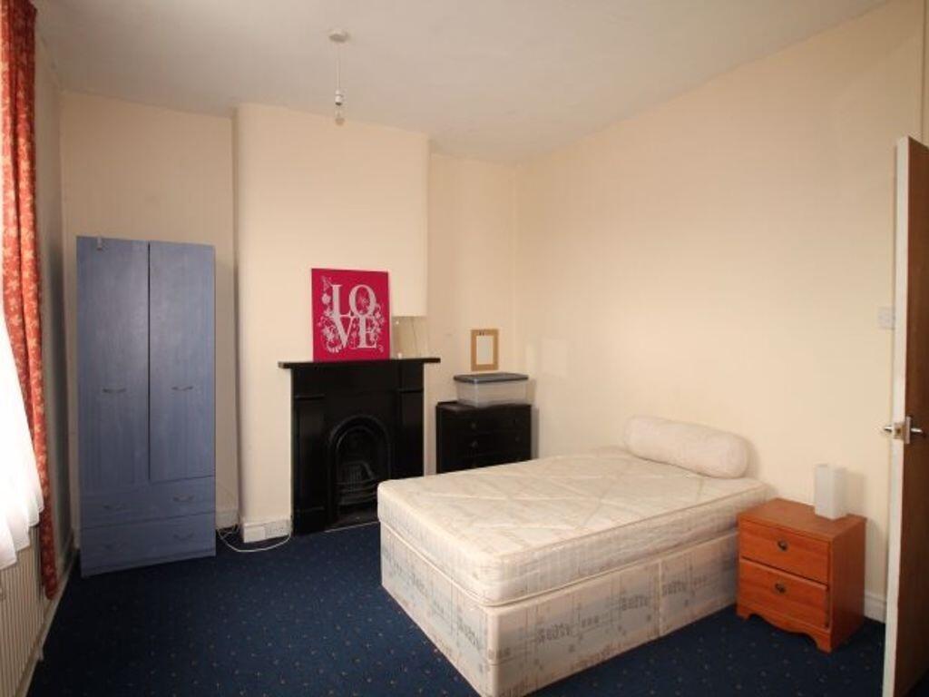 A cozy single bedroom featuring a single bed, a...