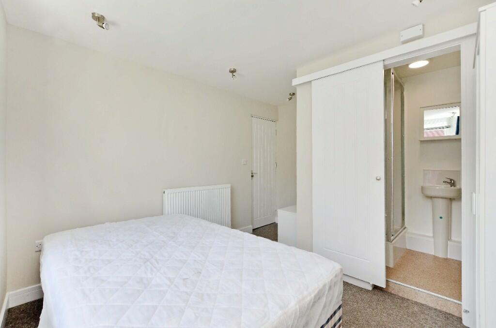 A tidy double bedroom featuring a comfortable b...