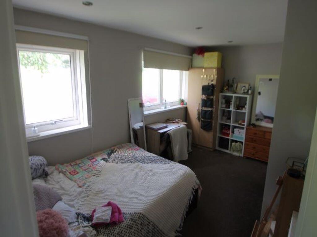 A cozy single bedroom featuring a comfortable b...