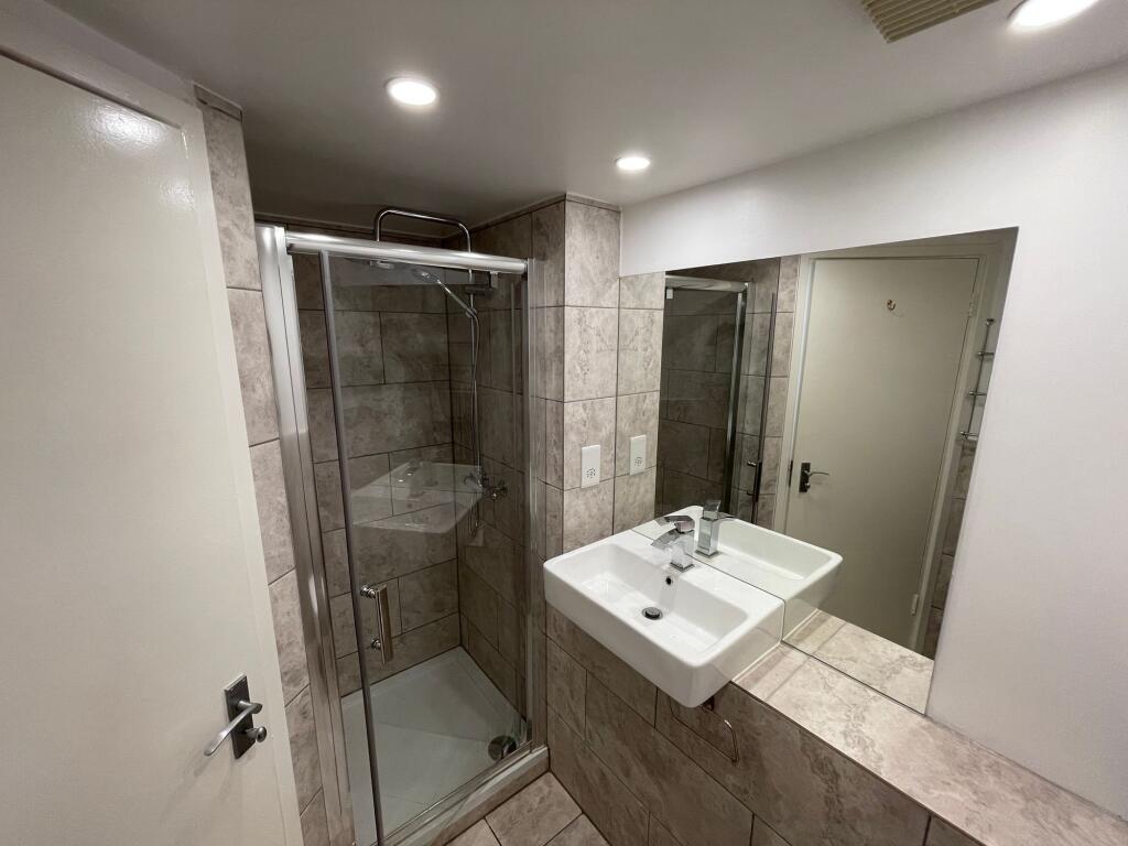 A modern bathroom featuring a clean glass showe...