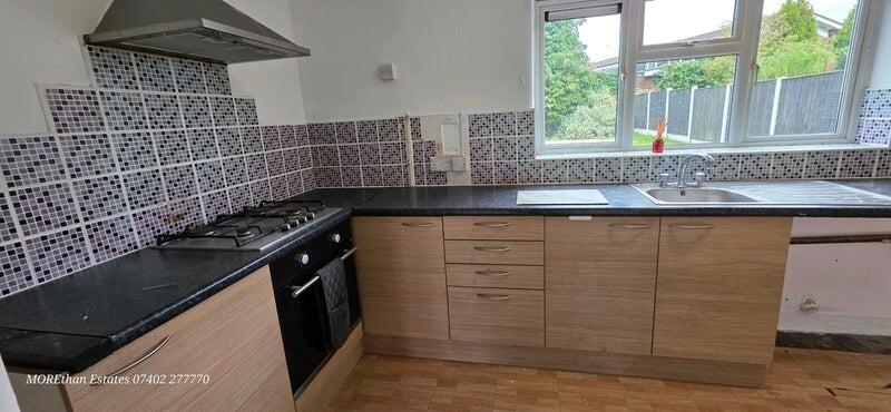 Modern kitchen with ample natural light, featur...