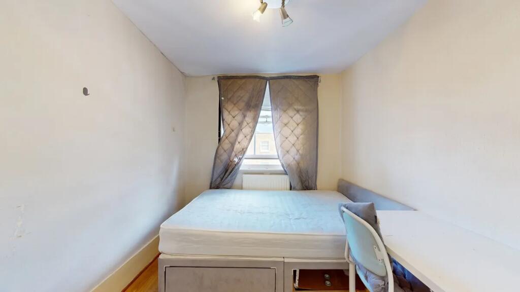 Cozy single bedroom featuring a comfortable bed...