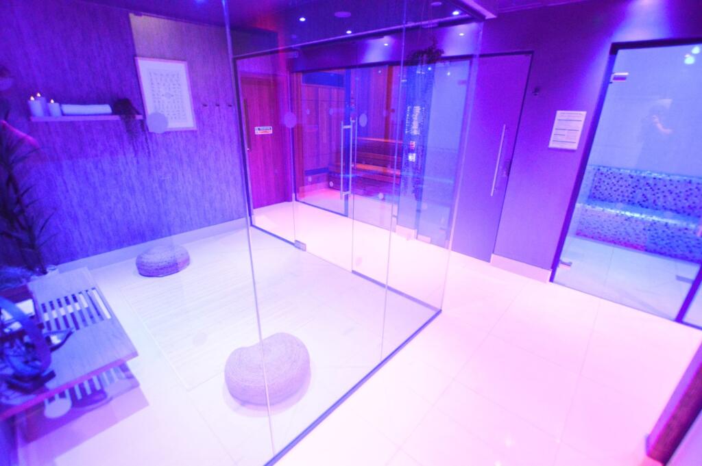 A sleek and modern gym area featuring glass par...