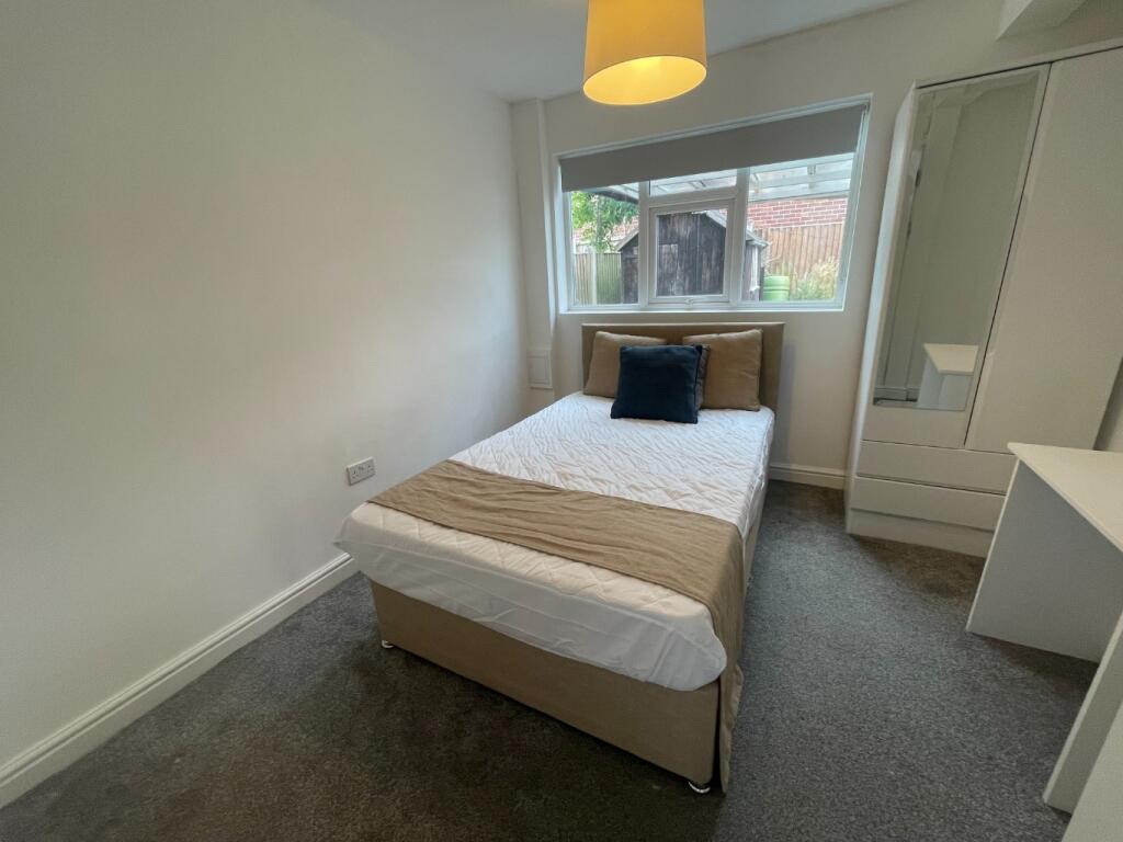 This inviting double bedroom features a cozy be...