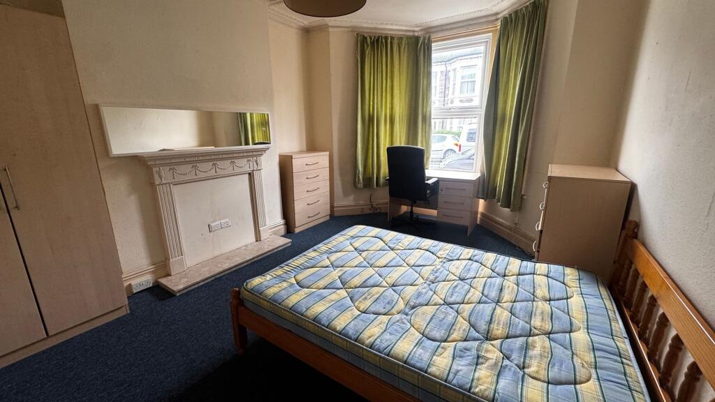 A cozy bedroom featuring a wooden bed frame wit...