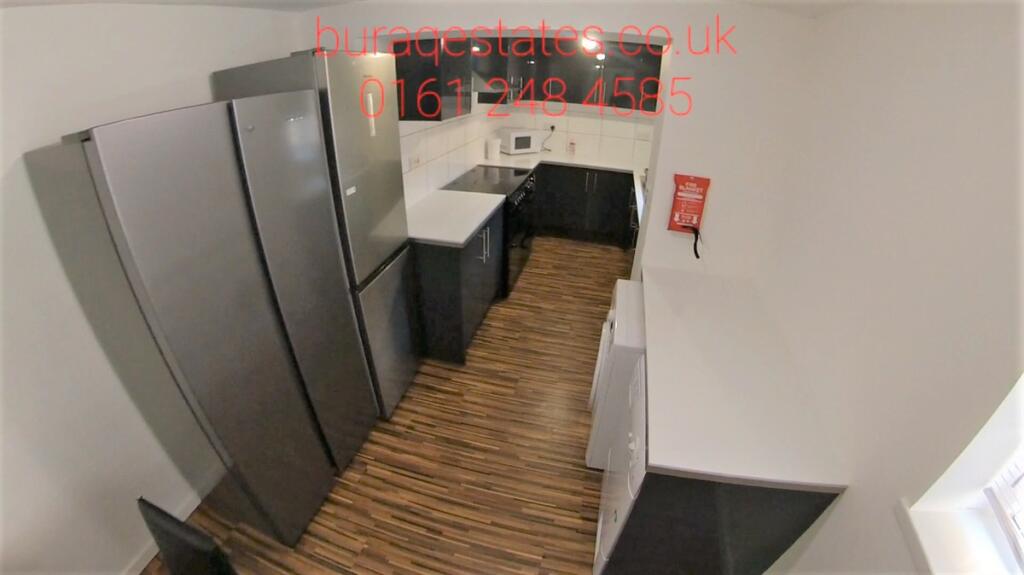 Modern kitchen with sleek appliances and dark c...