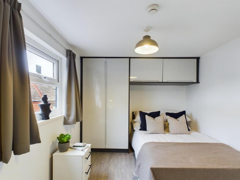 A beautifully organized double bedroom featurin...