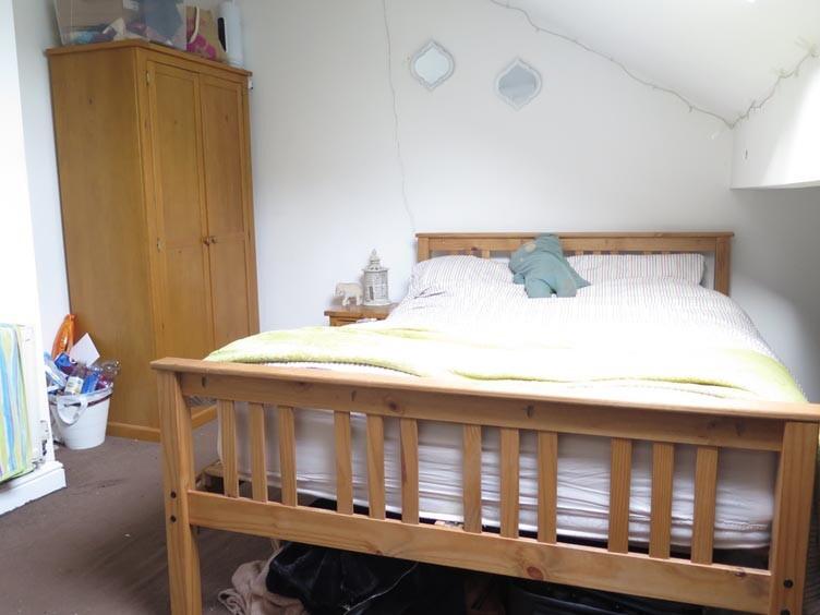 A cozy single bedroom with a comfortable bed an...