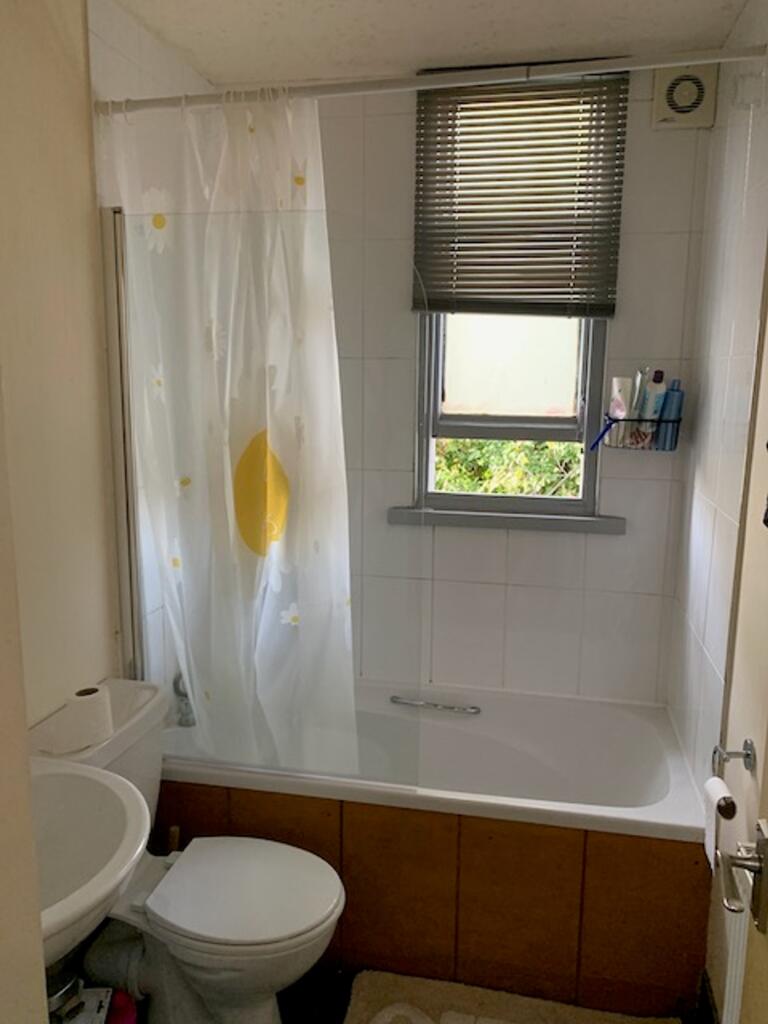 A tidy and functional bathroom featuring a bath...