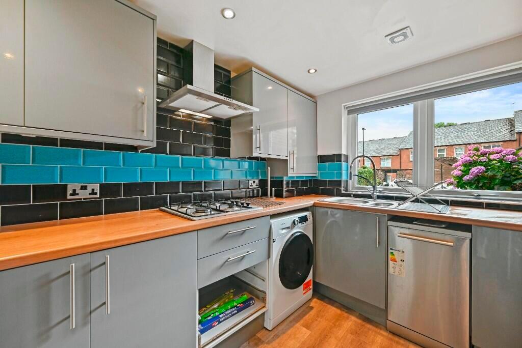 Modern kitchen featuring sleek grey cabinetry w...