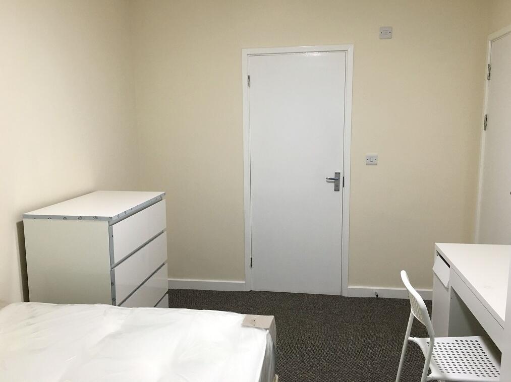 A neat and simple single bedroom featuring a wh...